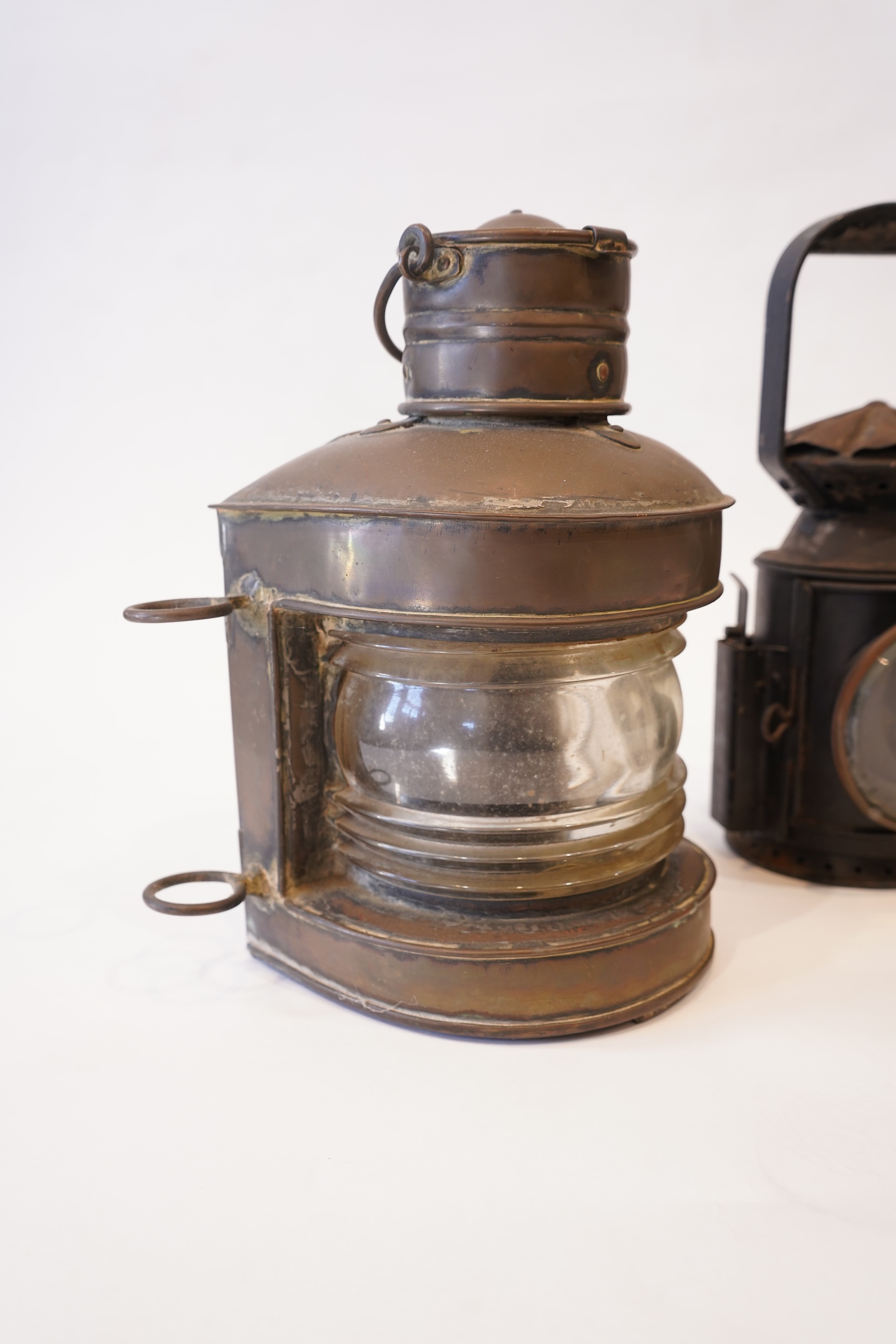 Two black painted railway hand lamps by Pratt & Co. Ltd. Birmingham, both dated 1945, both with burners and reflections, one intended for three colour aspect, with one glass missing, together with a brass ship’s bulkhead